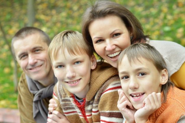 Glückliche vierköpfige Familie, die im Herbst zusammen im Park steht