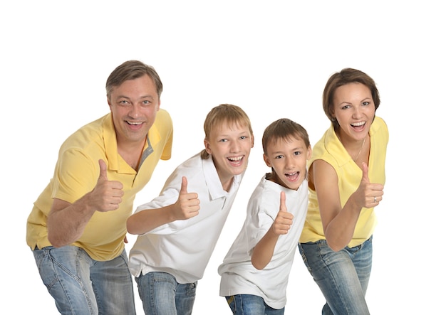 Glückliche vierköpfige Familie zeigt Daumen nach oben auf weißem Hintergrund