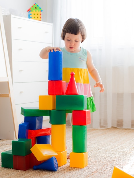 Glückliche Vorschulkinder spielen mit Bauklötzen.