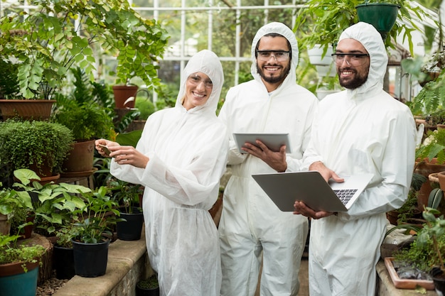 Glückliche Wissenschaftler im sauberen Anzug mit Technologien