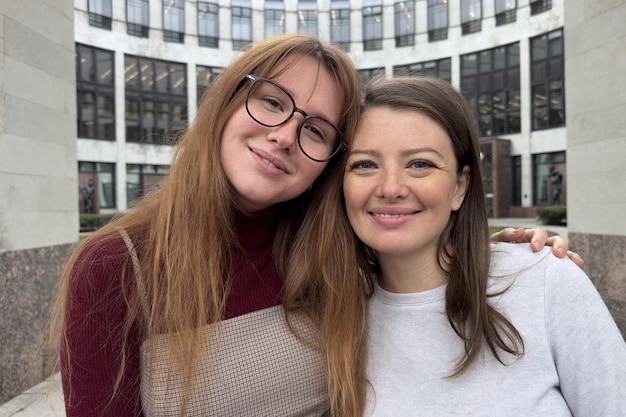 Glückliche zwei Studenten, junge lesbische LGBT-Frauen draußen auf dem Campus, glückliche homosexuelle weibliche Familie