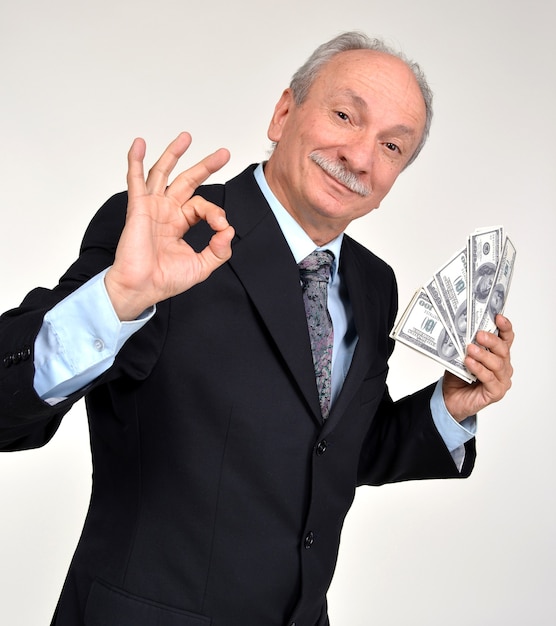 Foto glücklicher älterer mann, der dollar hält
