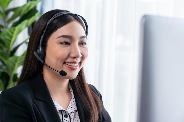 Glücklicher asiatischer Callcenter-Betreiber mit Headset Jubilant