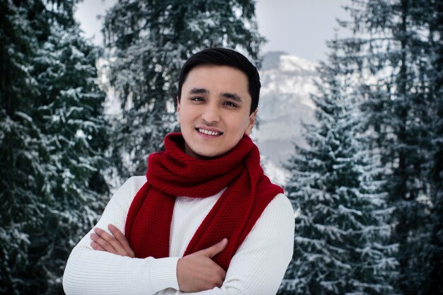 Glücklicher asiatischer junger Mann mit Winterkleidung.