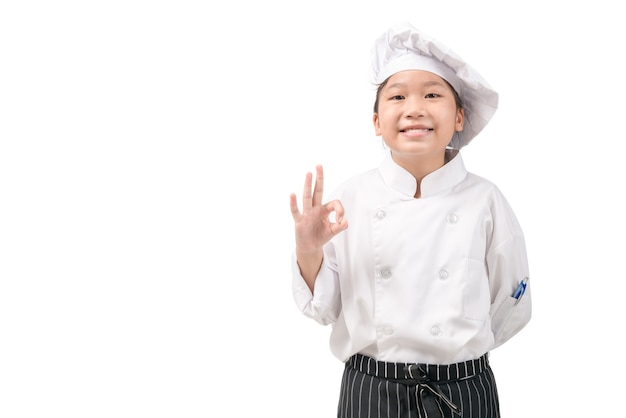 Glücklicher asiatischer Mädchenkoch in der Uniform, die OK Zeichen zeigt