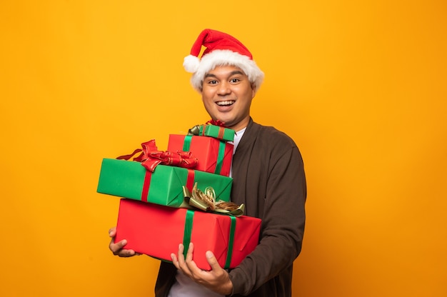 Glücklicher asiatischer Mann, der Weihnachtsgeschenke hält