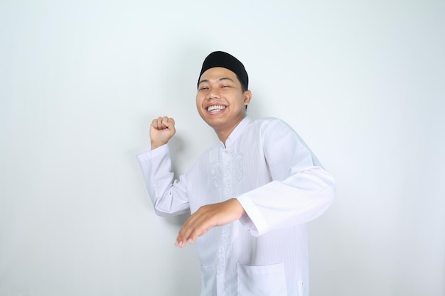 Foto glücklicher asiatischer muslimischer mann, der in die kamera schaut und etwas isoliert auf weißem hintergrund wirft