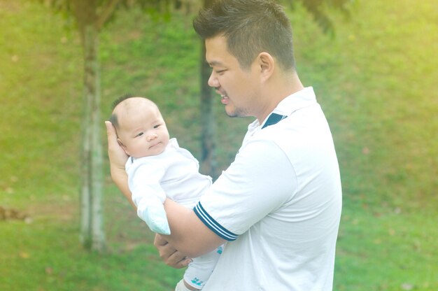 Glücklicher asiatischer Vater und Sohn, welche die Zeit im Freien an einem Sommertag verbringt