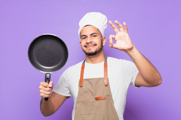 Glücklicher Ausdruck des jungen hispanischen Mannes. Kochkonzept