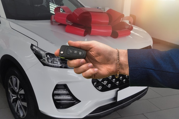 Glücklicher Autobesitzer macht ein Foto mit den Schlüsseln, bevor er einen neuen Kauf tätigt