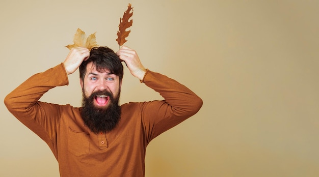 Glücklicher bärtiger Mann mit gelben Herbstblättern Herbstkleidung für saisonale Mode für Männer