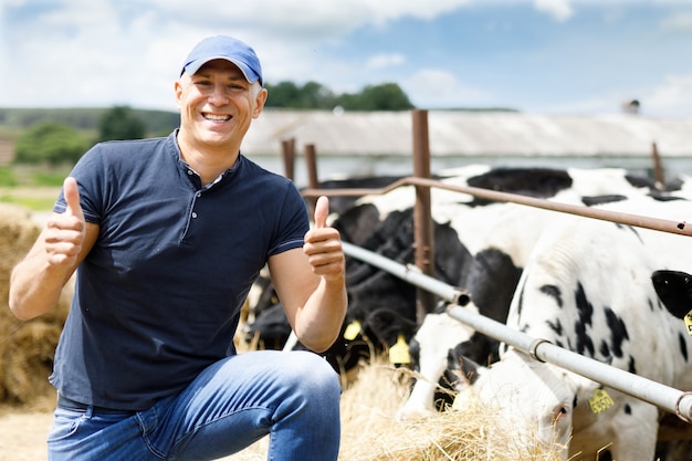 Glücklicher Bauer arbeitet auf Kuhfarm