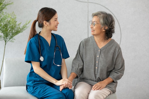Glücklicher Betreuer und älterer Patient lächeln und suchen Kamera Pflege zu Hause asiatische ältere Mann und Arzt kümmern sich und Empathie für den Patienten oder Ruhestand in der Homecare-Dienstleistung Altenpflege-Konzept