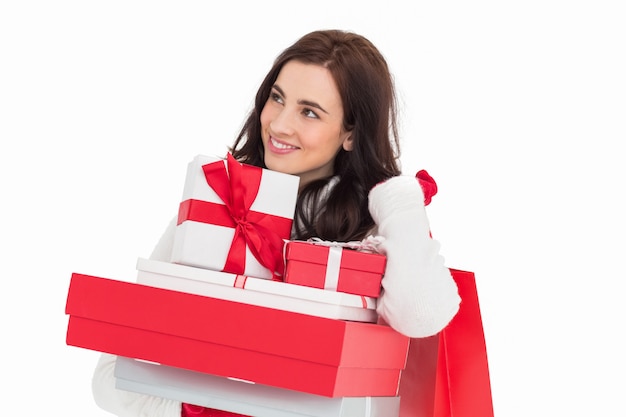 Glücklicher Brunette, der Weihnachtsgeschenke und Einkaufstaschen hält