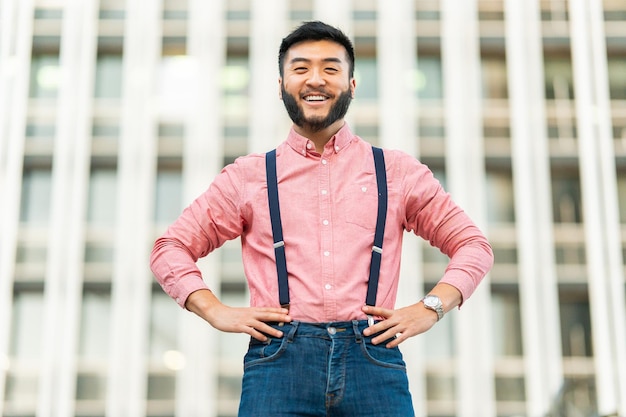 Glücklicher chinesischer Mann in Freizeitkleidung, der in die Kamera lächelt
