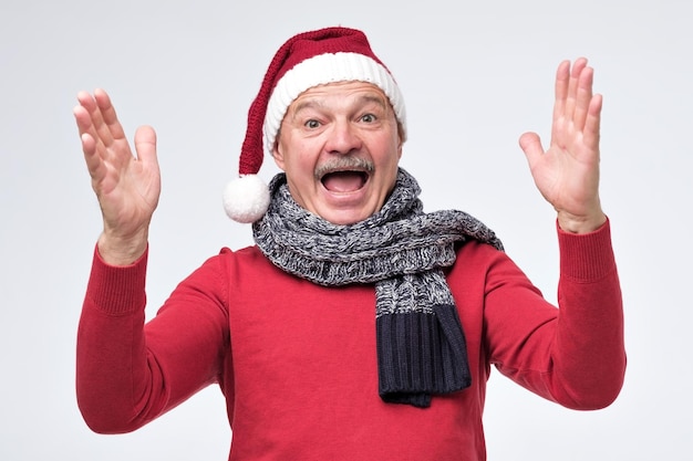 Foto glücklicher emotionaler mann, der weihnachtsweihnachtsmütze trägt, die große größe zeigt