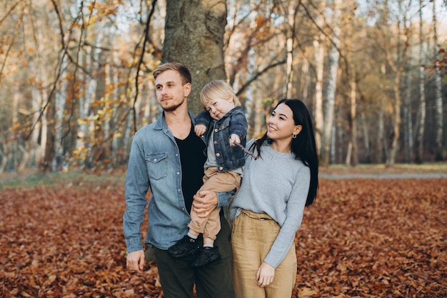 Glücklicher Familienmuttervater und -baby auf Herbstspaziergang im Park