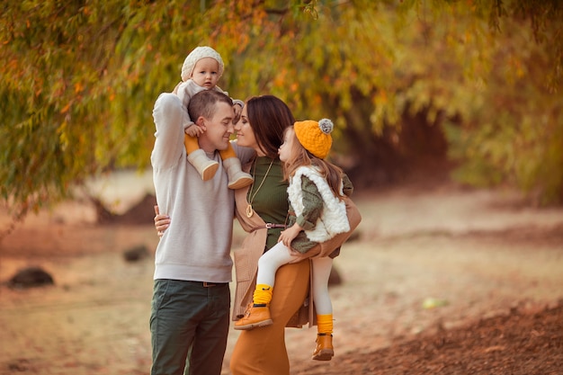 Glücklicher Familienmuttervater und zwei Töchter auf einem Spaziergang in der Natur im Herbst