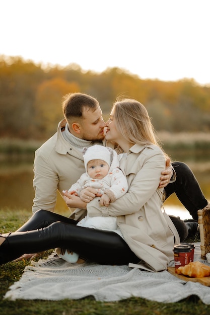 Glücklicher Familienspaziergang im Herbst im Park. Das Kind, die Mutter, der Vater haben Spaß im Park. Familie