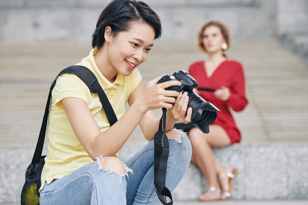 Glücklicher Fotograf, der Fotos überprüft