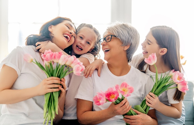 Glücklicher Frauentag Kindertöchter gratulieren Mutter und Oma und schenken ihnen Blumentulpen