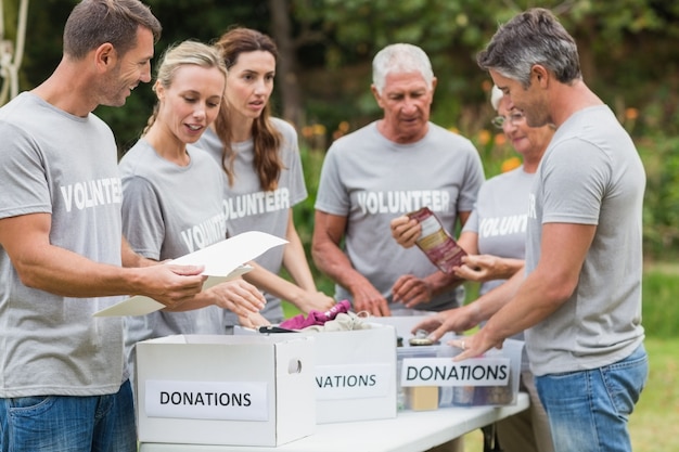 Glücklicher Freiwilliger, der Spendenkasten betrachtet