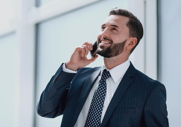 Glücklicher Geschäftsmann, der am Handy spricht