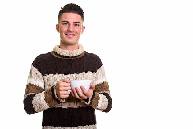 glücklicher gutaussehender Mann, der lächelt, während Kaffeetasse hält