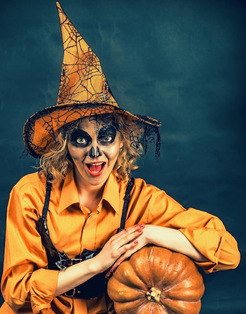 Glücklicher Halloween-Zauberer Sinnliche Frau im Hexen-Halloween-Kostüm mit Kürbislaterne Lustige Frau gekleidet wie Halloween-Monster