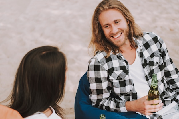 Glücklicher Hippie-Mann und Frau sprechen am Strandfest