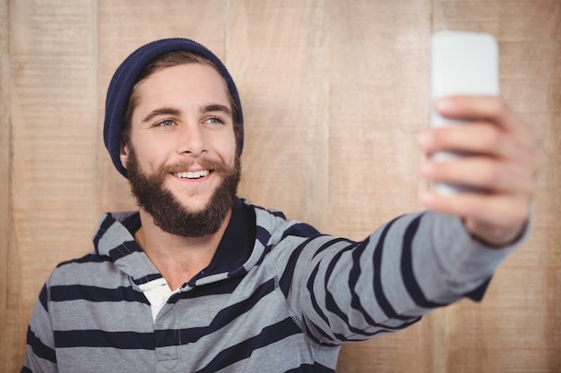 Glücklicher Hippie mit dem mit Kapuze Hemd, das selfie nimmt