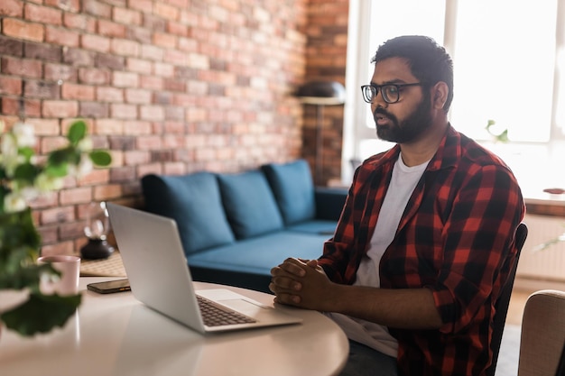 Glücklicher indischer freiberufler oder unternehmer haben videokonferenzgespräche, die aus der ferne online im heimbüro arbeiten, kopierraum videoanruf und diversitätskonzept