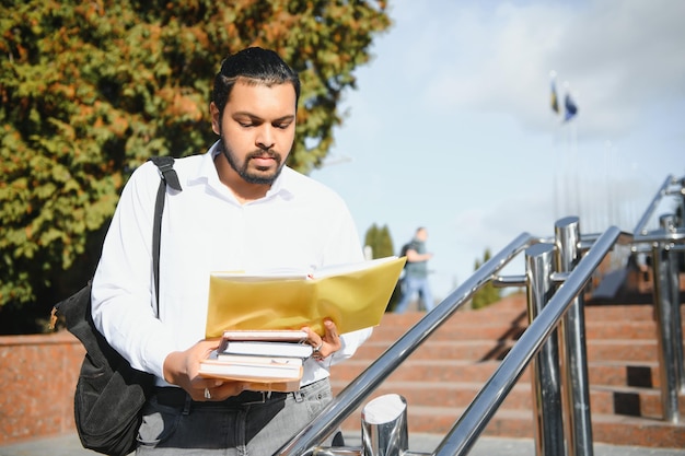 Glücklicher indischer männlicher Student an der Universität