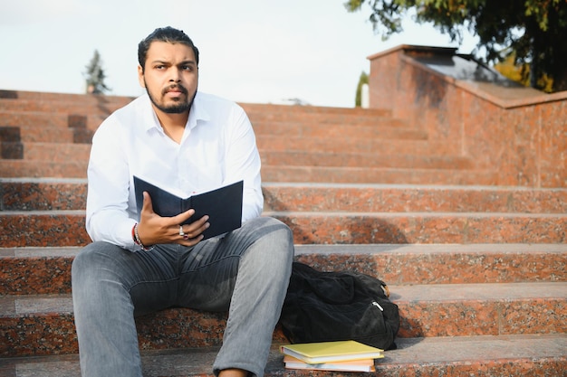 Glücklicher indischer männlicher Student an der Universität