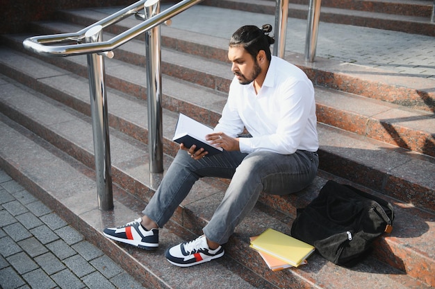 Glücklicher indischer männlicher Student an der Universität