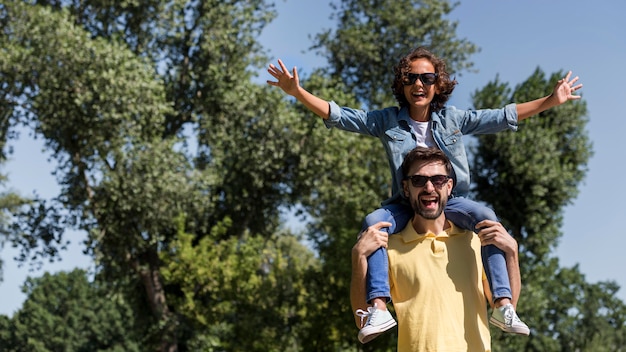 Foto glücklicher junge, der mit seinem vater im park spielt