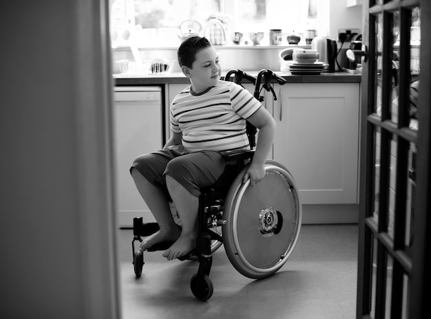 Glücklicher Junge im Rollstuhl
