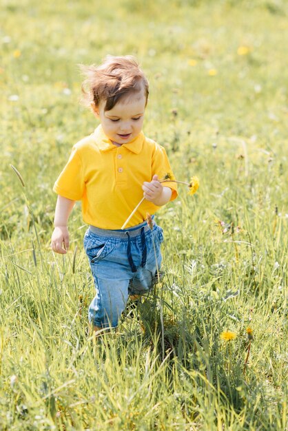 Glücklicher Junge läuft und spielt draußen auf einem Feld