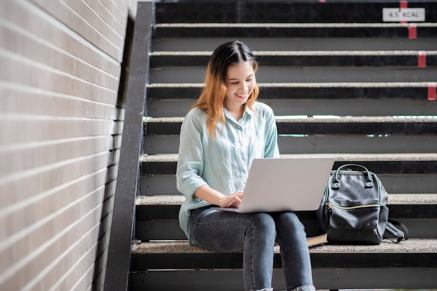 Glücklicher junger asiatischer Universitätsstudent