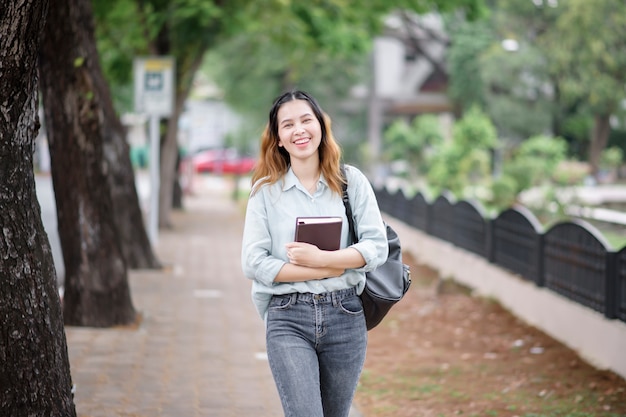 Glücklicher junger asiatischer Universitätsstudent.