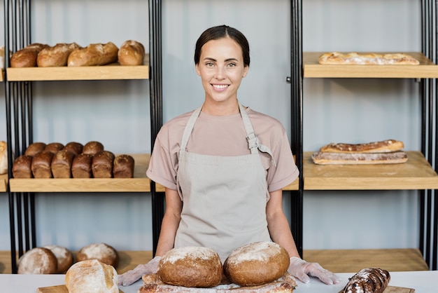 Glücklicher junger Besitzer einer Bäckerei, die frisches Brot verkauft?