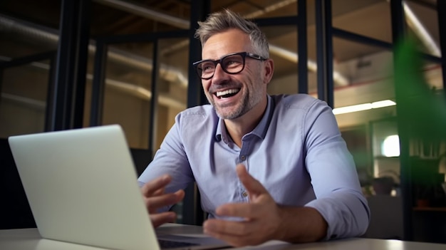 Glücklicher junger Mann mit Brille und Lächeln, während er an seinem Laptop arbeitet, um alle seine Geschäfte zu erledigen