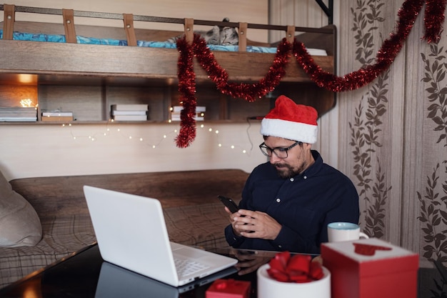 Glücklicher junger Mann mit lustiger Katze zu Hause Weihnachtsgeschenkboxen