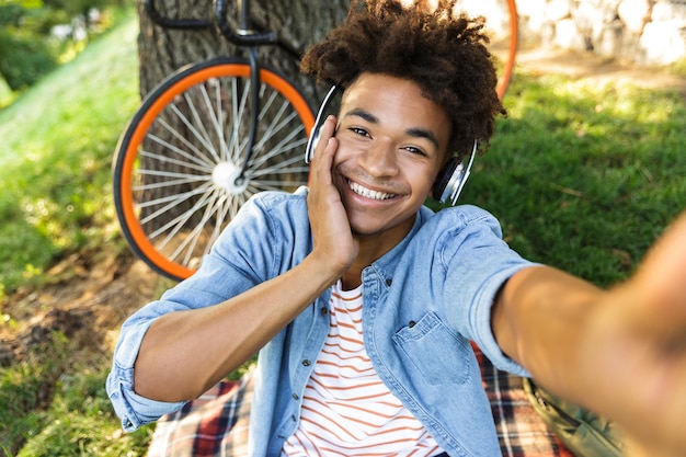 Glücklicher junger Teenager mit Fahrrad im Freien