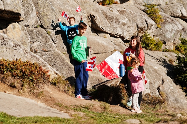 Glücklicher Kanada-Tag. Familie der Mutter mit drei Kindern hält große kanadische Flaggenfeier in den Bergen ab.