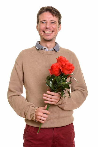 Glücklicher kaukasischer Mann, der rote Rosen bereit für Valentinstag hält