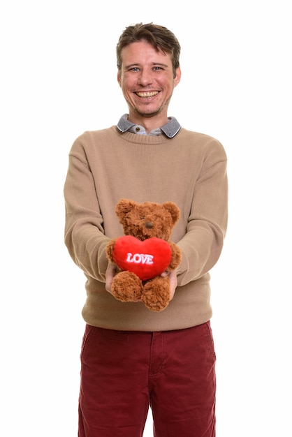 Glücklicher kaukasischer Mann, der Teddybär mit Herz- und Liebeszeichen hält