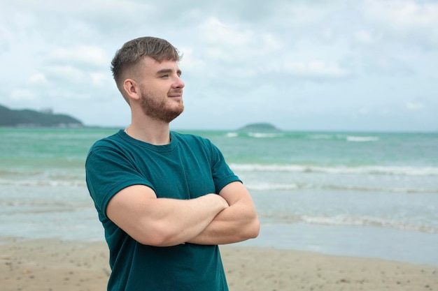 Glücklicher Kerl, junger gutaussehender Mann genießt Sommerferien am Meeresstrand in tropischem exotischem Land und lächelt und hat Spaß