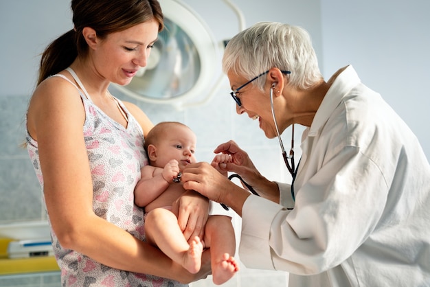 Glücklicher Kinderarzt untersucht Baby. Gesundheitswesen, Menschen, Untersuchungskonzept