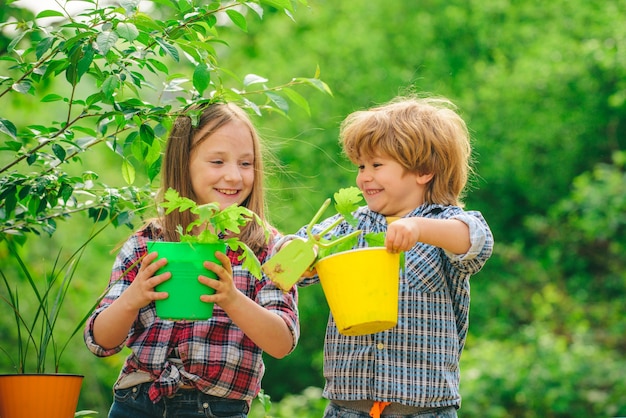 Glücklicher Kinderbauer auf dem Bauernhof mit Landschaftshintergrund süßer kleiner Junge und Mädchen Bewässerungsplan...